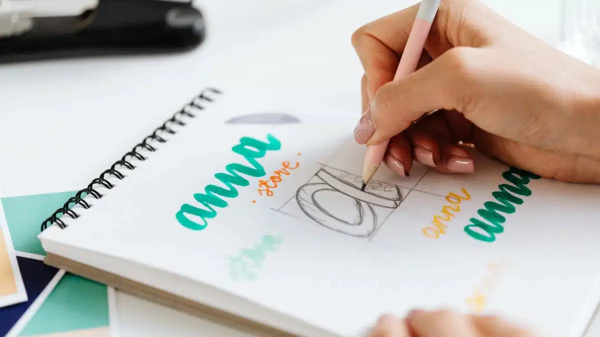 A person designing a font on a spiral book