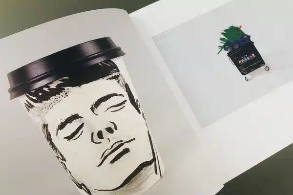 An artist exploring a collection of comic books printed at Ex Why Zed for research and inspiration