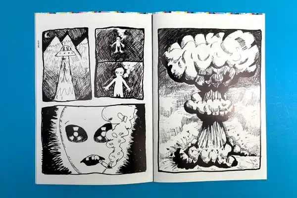 An artist exploring a collection of comic books printed at Ex Why Zed for research and inspiration