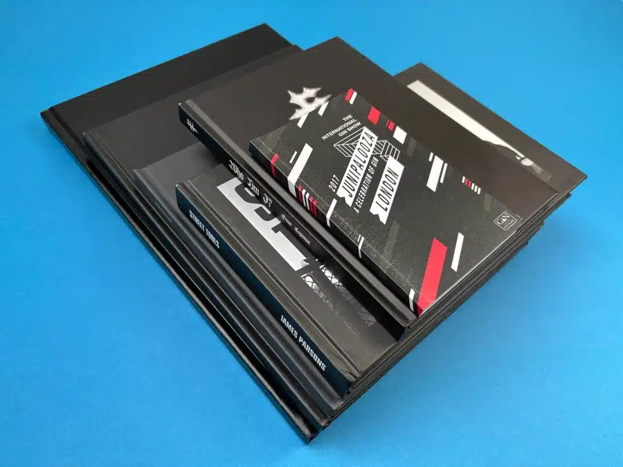 Variety of printed book sizes by Ex Why Zed displayed upright on blue background.