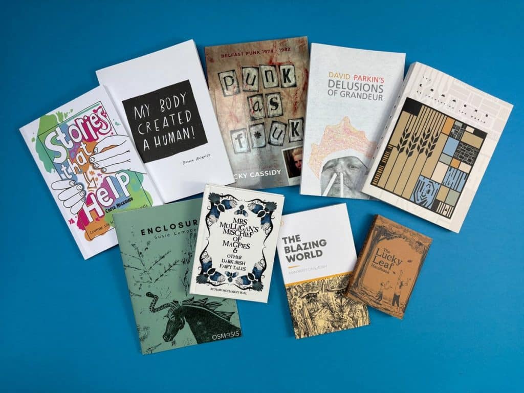 Hero image showing a stack of beautifully printed self-published novels and graphic novels by Ex Why Zed, representing the cost of printing a book.