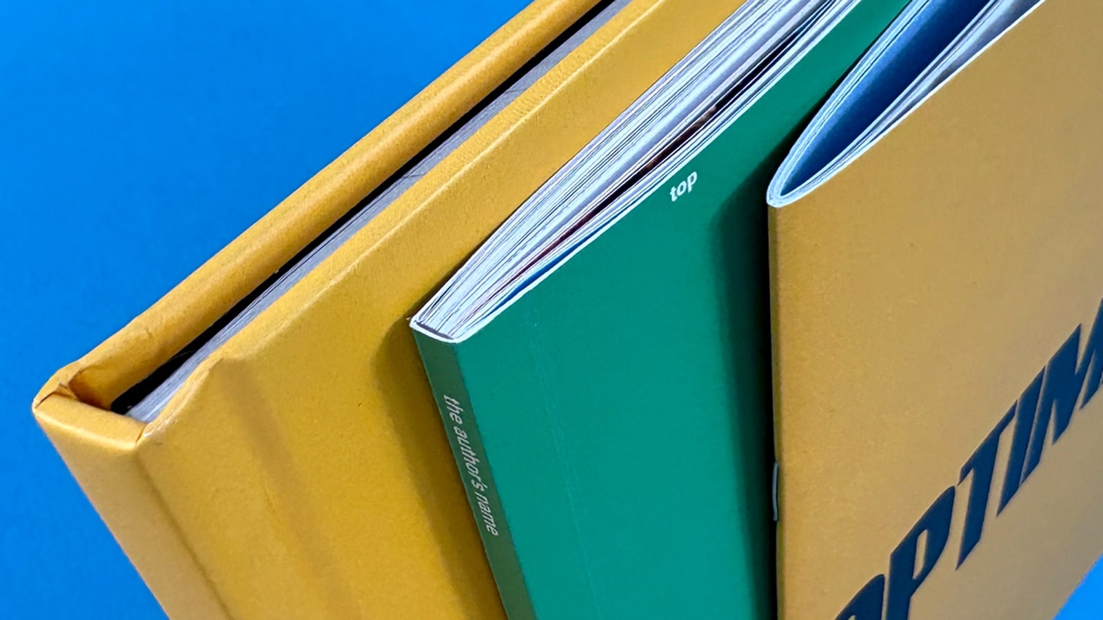 Stacks of printed sheets being handled in production, representing professional book and booklet binding styles at Ex Why Zed.