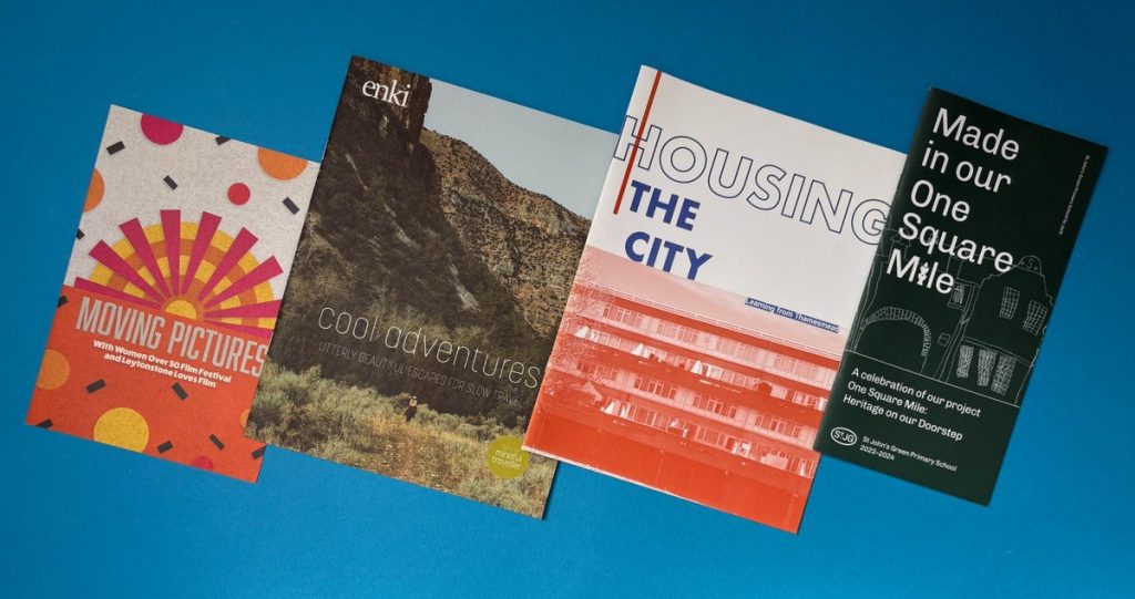 Printed booklets and creative publications laid out on a blue background for an offset printing guide.