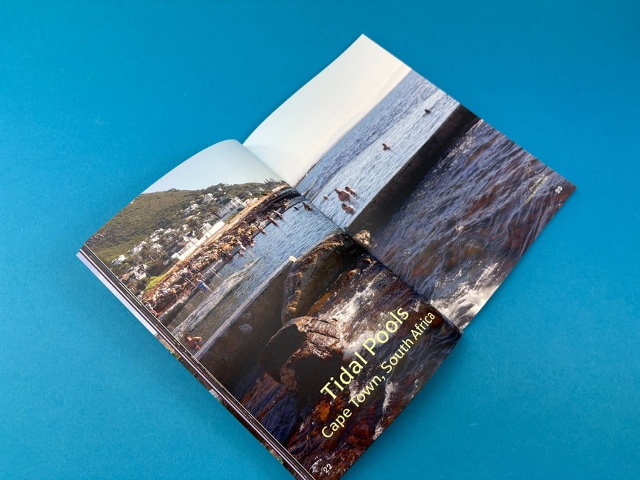 Open travel magazine with a full-bleed coastal photography spread showing how format shapes visual storytelling.