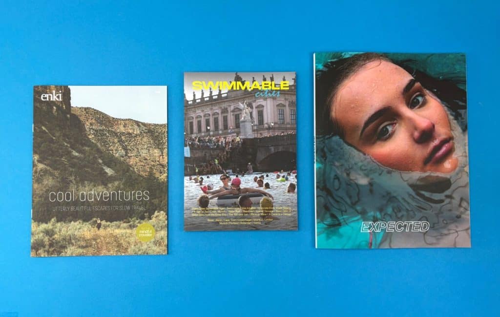 Three professionally printed magazines displayed together on a blue background for a magazine printing guide.