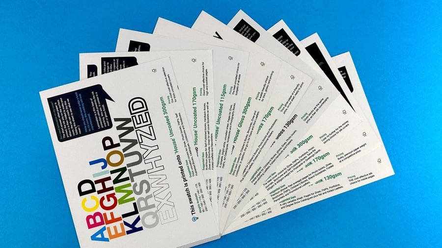Ex Why Zed paper sample cards fanned out to show different magazine paper stocks and finishing options.