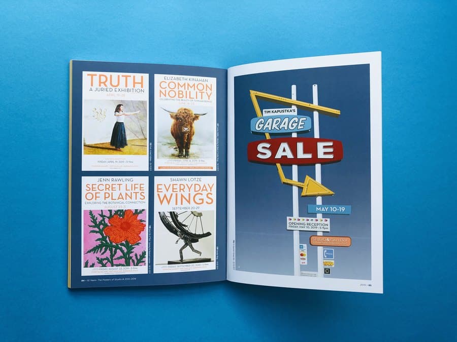 Printed art book spread showing multiple poster designs, an economical way for artists to reproduce a collection of digital artwork.