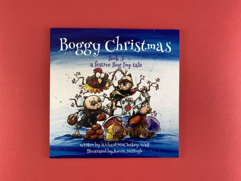 Square Christmas picture book cover of bog imps decorating a berry branch with a turkey under a painted blue sky