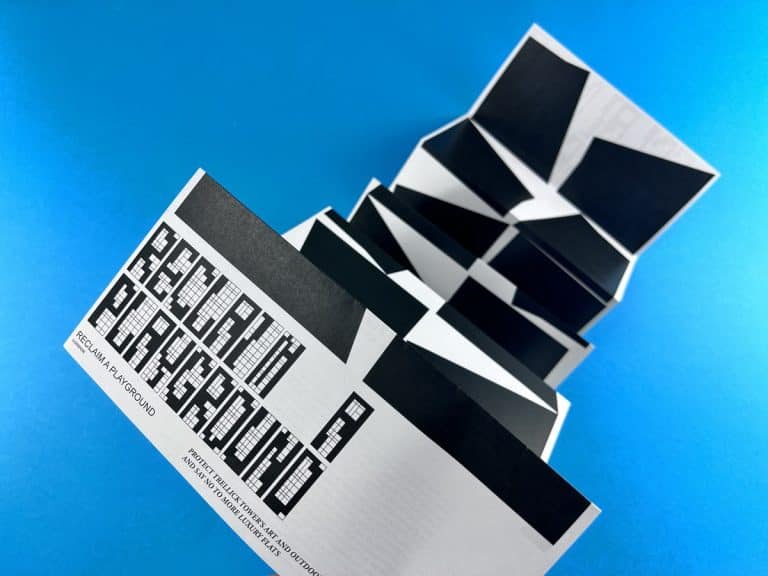 Concertina folded leaflet with a pixel-block Reclaim a Playground cover and bold black geometric panels rising behind it.